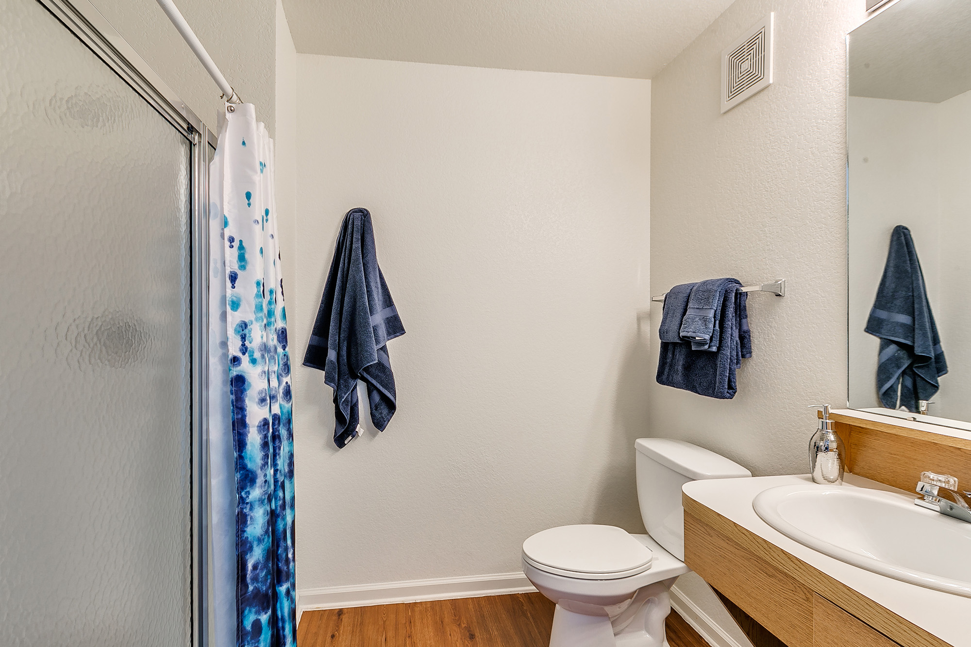 a bathroom with a blue shower curtain and toilet